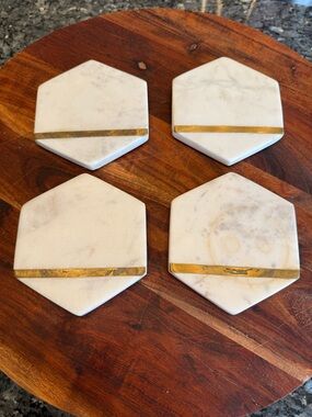 Hexagonal white marble coasters featuring a brass inlay design